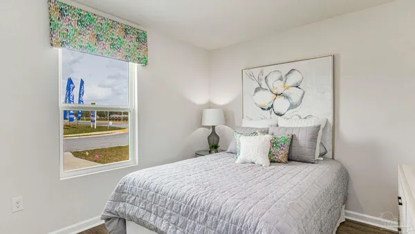 a bedroom with a bed and painting on the wall
