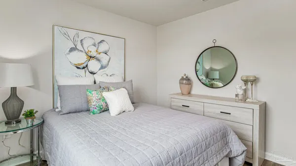 a bedroom with a bed and a painting on the wall