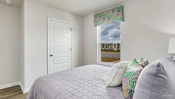 a bedroom with a bed and a painting on the wall