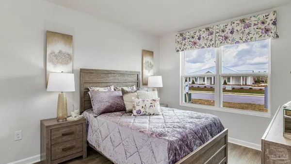 a bed sitting in a bedroom next to a window