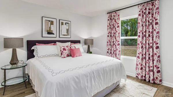 a bedroom with a bed and a lamp next to a window