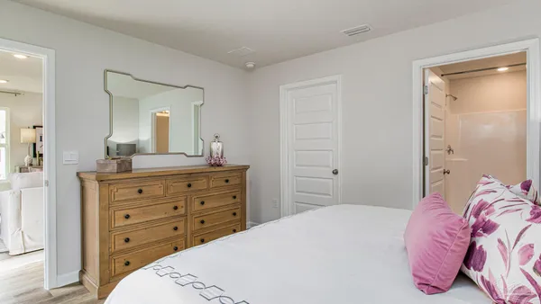 a bedroom with a bed and a mirror