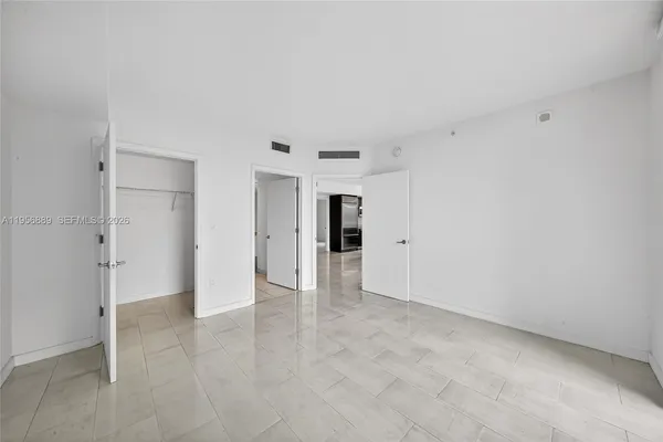 an empty room with floor to ceiling window and an entryway