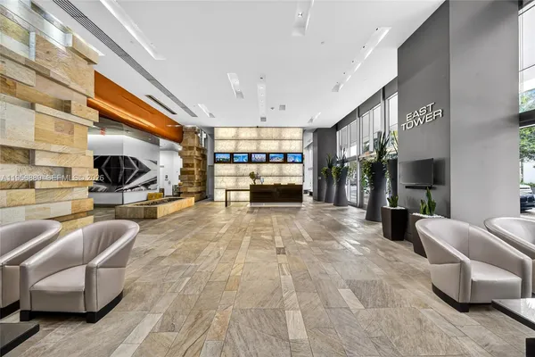 a living room with furniture and three large window