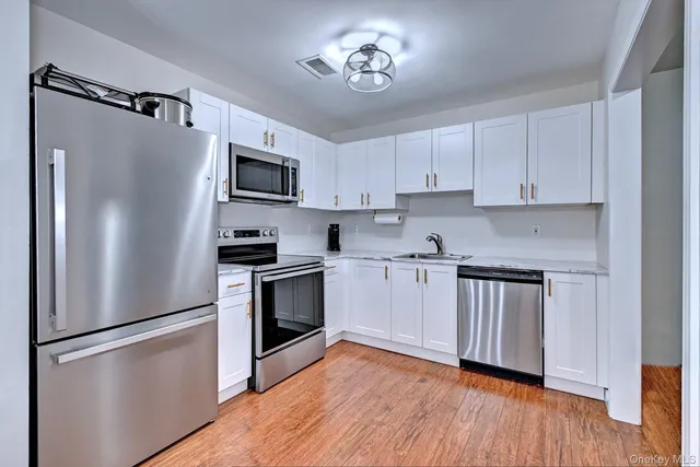 a kitchen with stainless steel appliances a refrigerator sink and microwave
