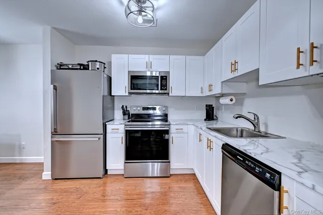 a kitchen with stainless steel appliances granite countertop a refrigerator sink and stove