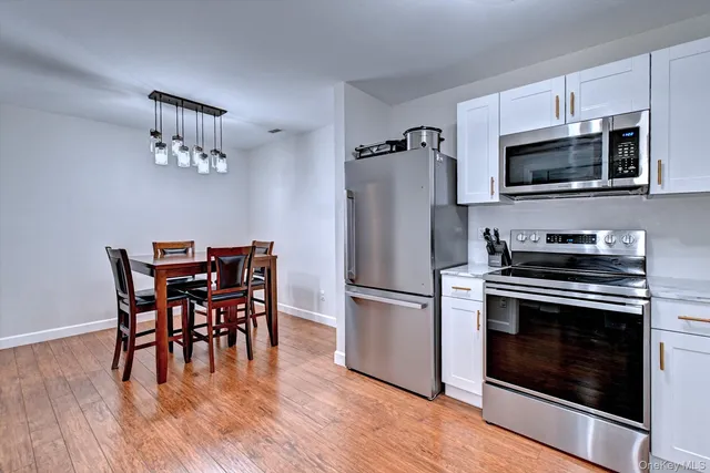 a kitchen with a dining table and stainless steel appliances