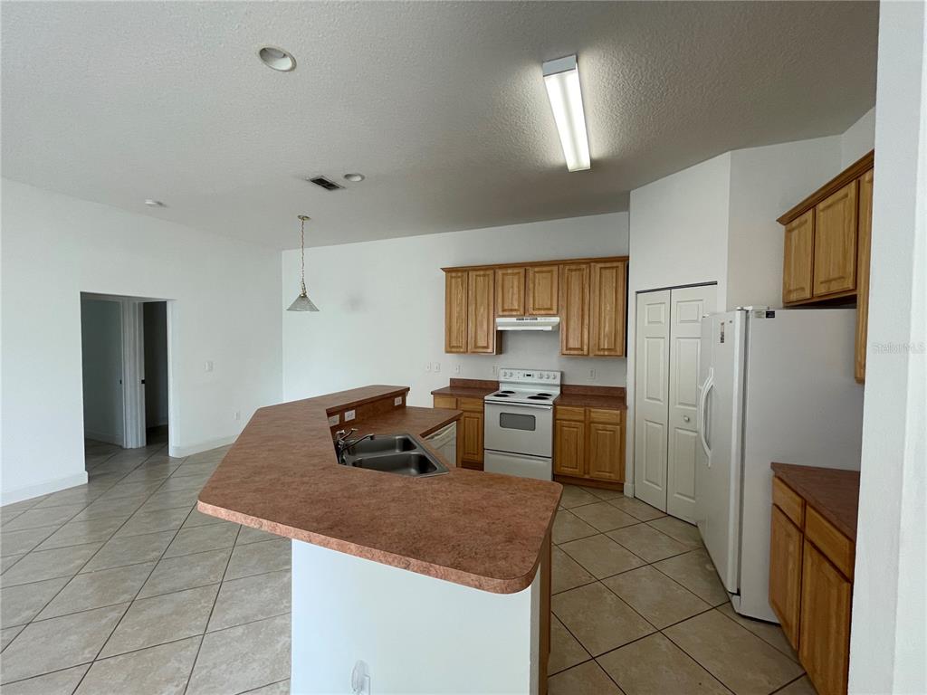 61 Buttonworth Drive, Unit A Palm Coast, FL 32137 - Photo 2 of 10 a kitchen with stainless steel appliances granite countertop a refrigerator and a stove top oven