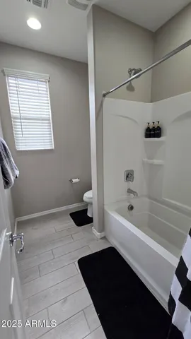a view of an empty room with wooden floor and closet