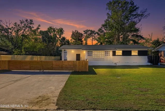 a view of a house with swimming pool next to a yard