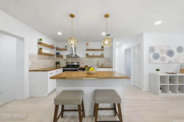 a kitchen with stainless steel appliances granite countertop a sink and a refrigerator