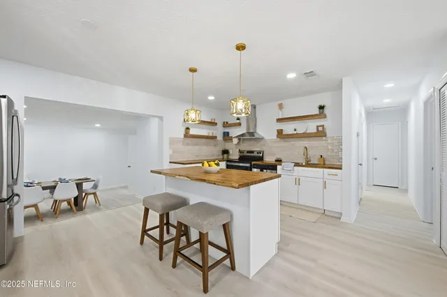 a kitchen with kitchen island granite countertop a sink cabinets and wooden floor