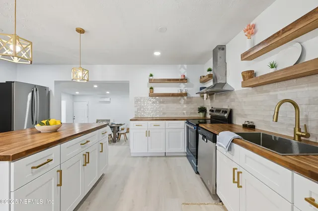 a kitchen with kitchen island granite countertop a sink a counter space appliances and cabinets