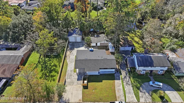 an aerial view of a house with swimming pool a yard and lake view