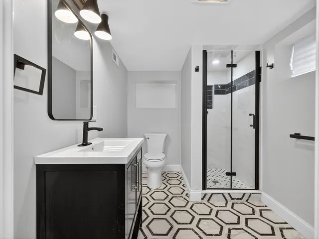 a bathroom with a sink a toilet and mirror