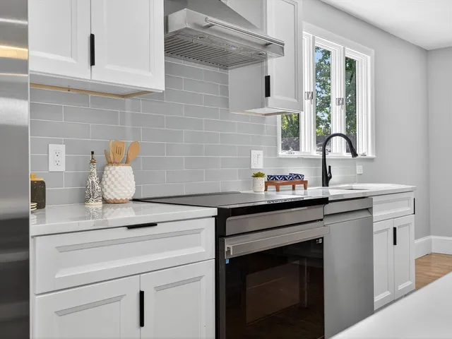 a sink with granite countertop white cabinets white stainless steel appliances a sink and window
