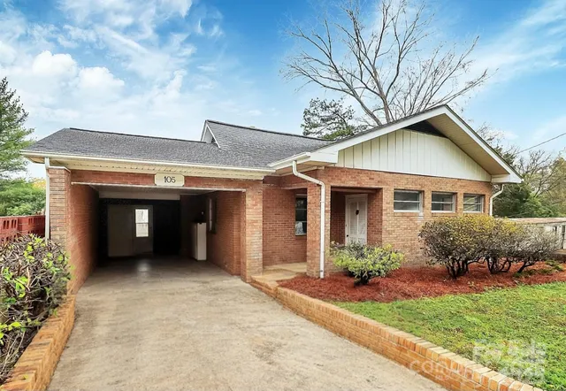 a front view of a house with a garden and plants