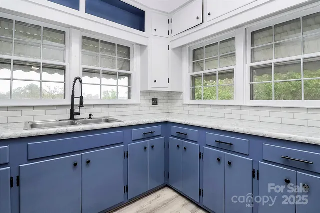 a kitchen with stainless steel appliances granite countertop a sink and a window