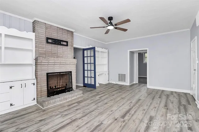 a view of empty room with wooden floor and fireplace