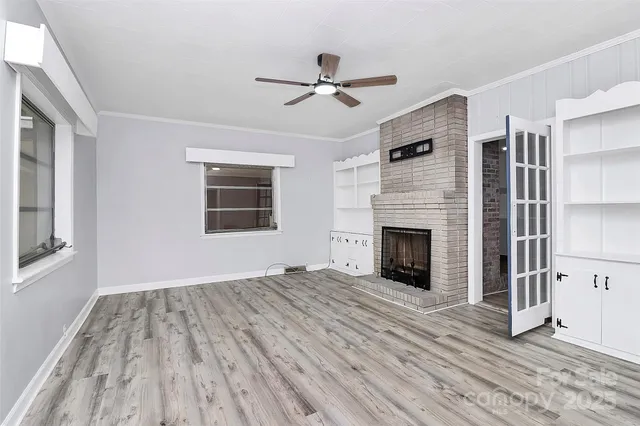 a view of empty room with wooden floor and fireplace