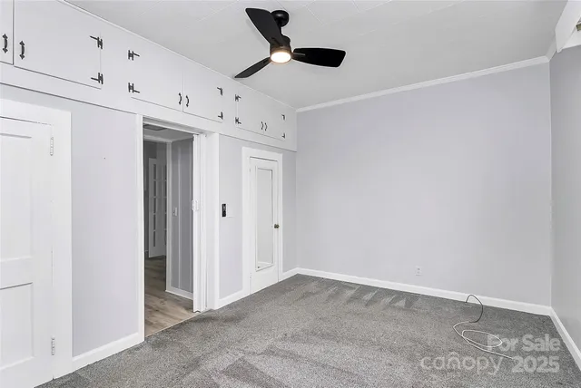 an empty room with a window and a ceiling fan