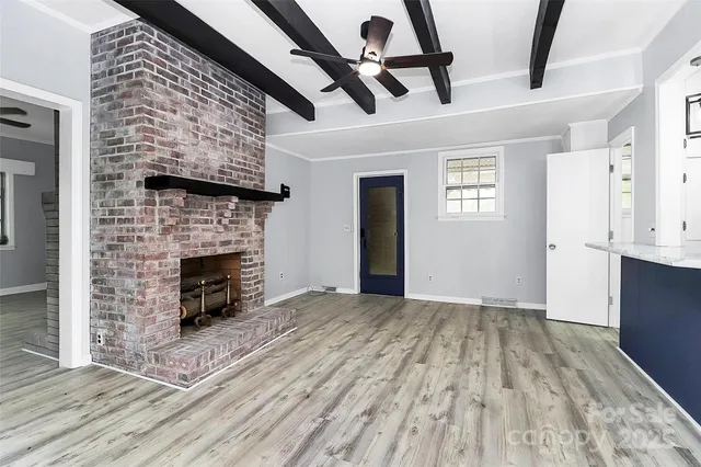 a view of empty room with wooden floor and fireplace