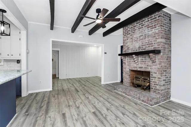 a view of empty room with wooden floor and fireplace