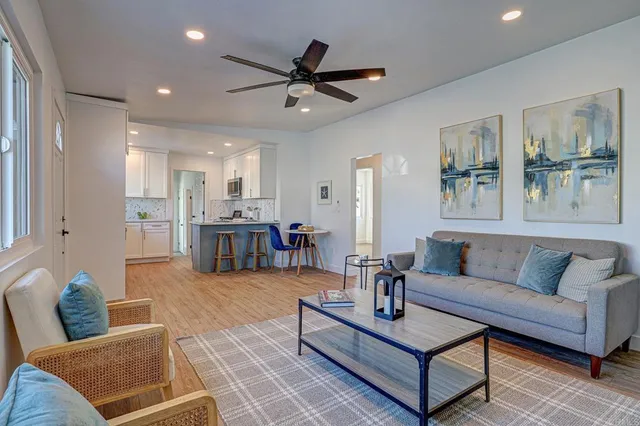 a living room with furniture and view of kitchen