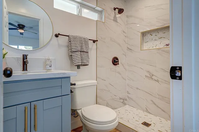 a bathroom with a sink a toilet and shower