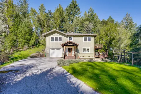 a front view of a house with yard and green space