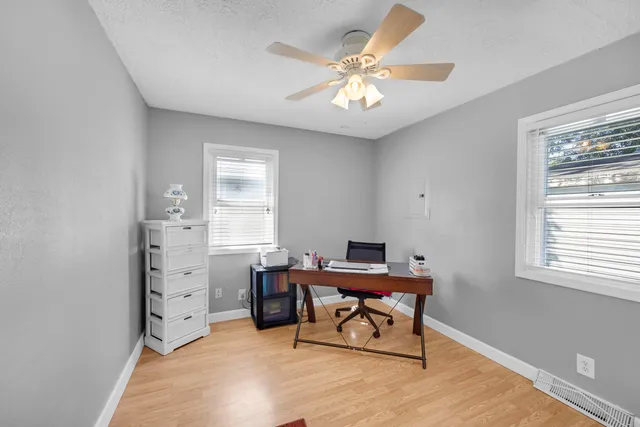 a workspace with wooden floor and a window
