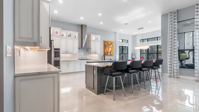 a large kitchen with stainless steel appliances lots of white cabinets