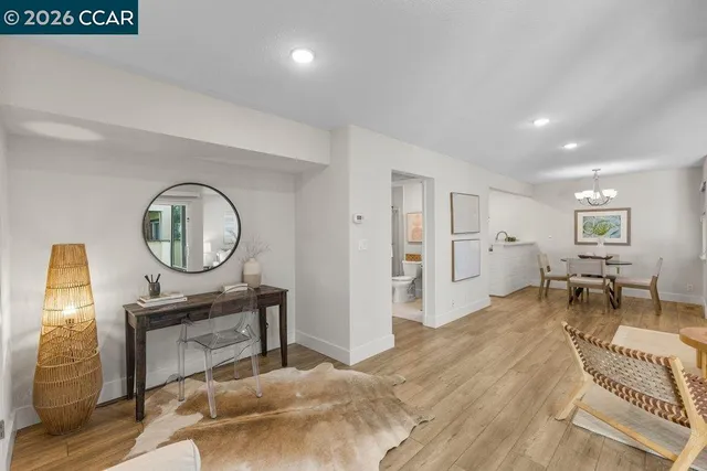 a living room with furniture a clock on wall and a table