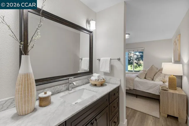 a bathroom with a granite countertop sink and a mirror
