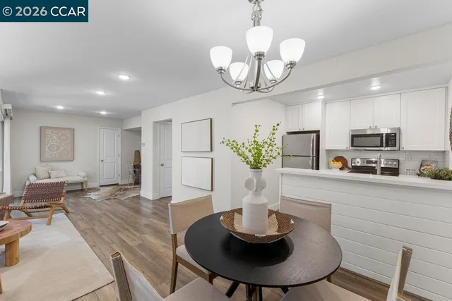 a kitchen with stainless steel appliances chandelier a refrigerator and dining table