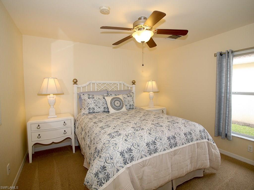 19636 Villa Rosa Loop Estero, FL 33967 - Photo 14 of 21 a bedroom with a bed and a chandelier