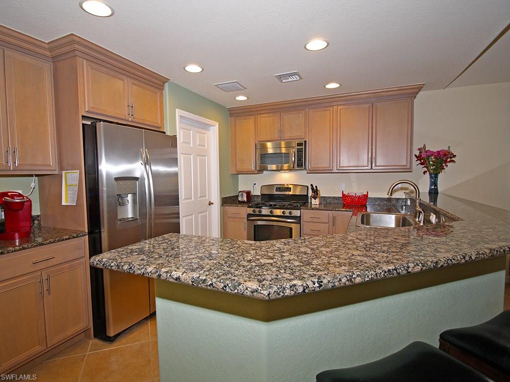 19636 Villa Rosa Loop Estero, FL 33967 - Photo 5 of 21 a kitchen with kitchen island granite countertop a sink a counter top space and appliances