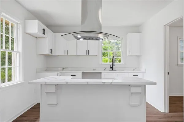 a kitchen with stainless steel appliances a sink window and cabinets