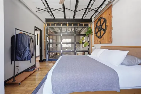 a bed room with a bed and a painting on the wall