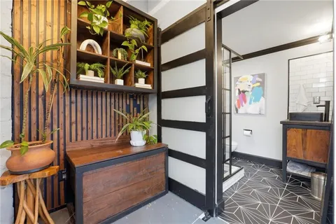 a view of a hallway with wooden floor and furniture