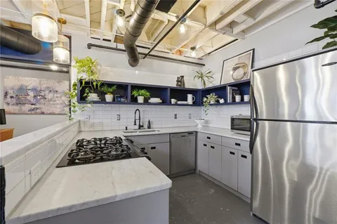 a kitchen with stainless steel appliances granite countertop a sink stove and refrigerator
