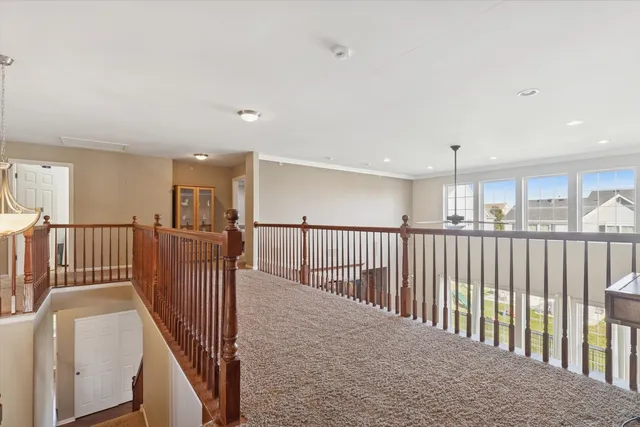 a view of a hallway with wooden floor and windows