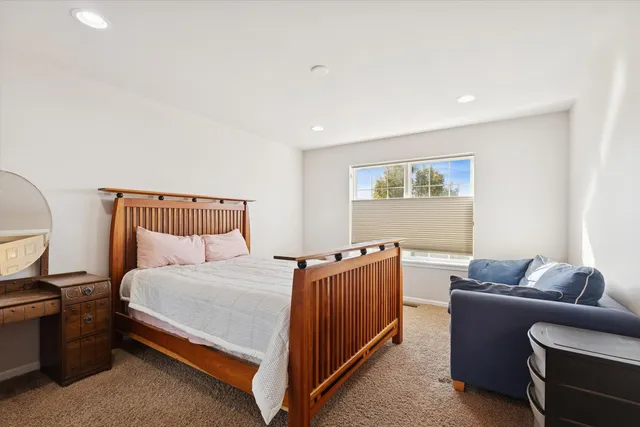 a bedroom with bed couch and window
