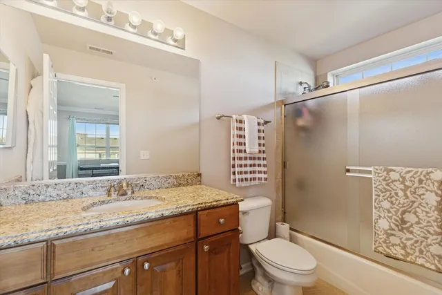 a bathroom with a granite countertop sink toilet and shower
