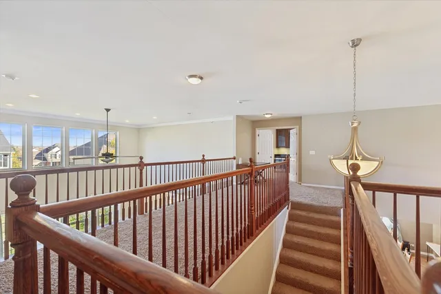a view of staircase with railing and a chandelier