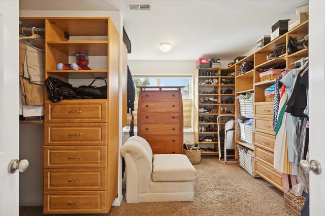 a view of walk in closet with clothes and shoes