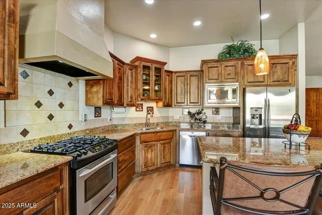 a living room with furniture kitchen view and a wooden floor