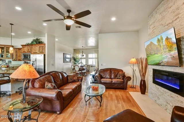 a kitchen with stainless steel appliances kitchen island granite countertop a refrigerator a stove a oven and white cabinets with wooden floors