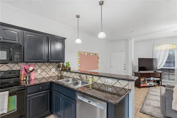 a kitchen with granite countertop a sink appliances and cabinets