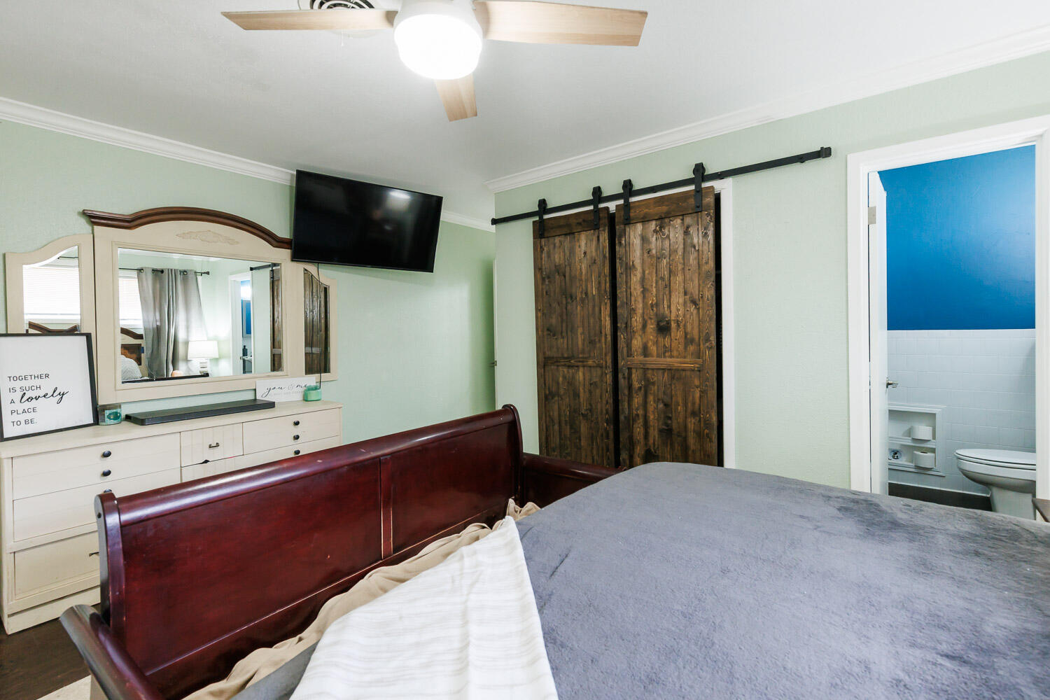 2718 55th Street Lubbock, TX 79413 - Photo 28 of 58 a bedroom with a bed and a flat tv screen on dresser